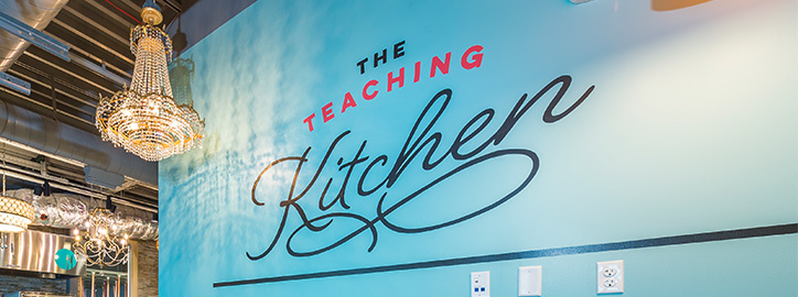 Teaching Kitchen wall with exhibit logo painted on it